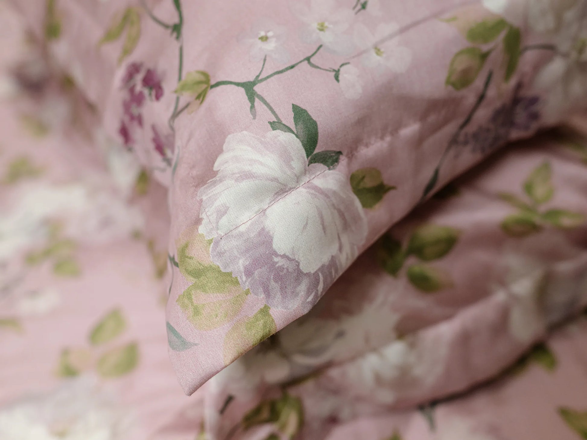 Close-up of blush pink floral print of 500 thread count organic cotton luxury bedsheet showing soft breathable fabric texture 