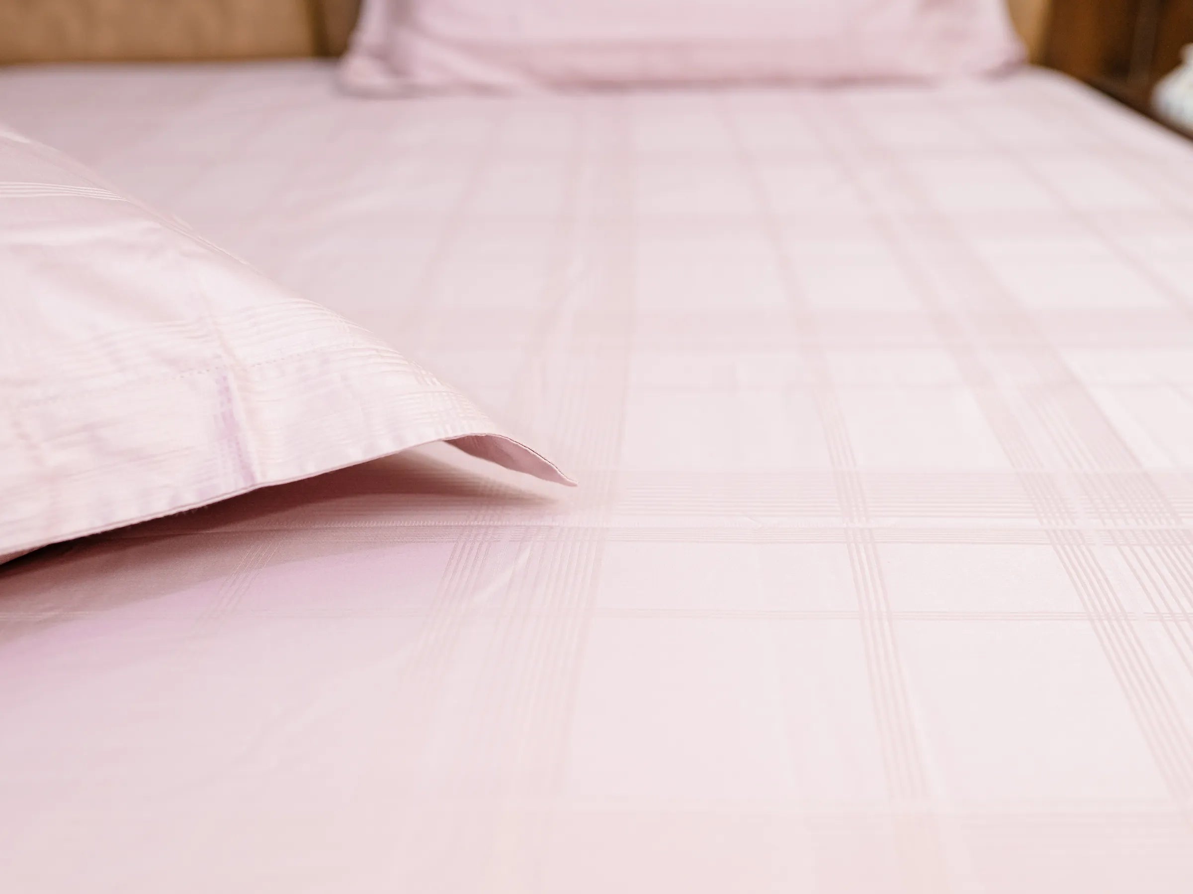 Close-up of Hush classic pink luxury bedsheet with matching pillow cover showcasing soft jacquard checks and premium cotton texture