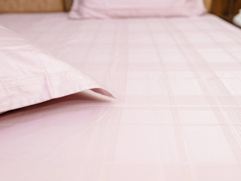Close-up of Hush classic pink luxury bedsheet with matching pillow cover showcasing soft jacquard checks and premium cotton texture