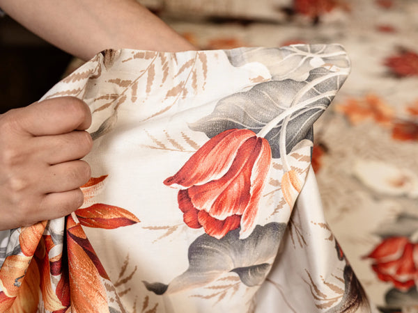 Close-up of Symmetry luxury cotton bedsheet fabric highlighting soft 500 thread count texture and artistic tropical flower print.