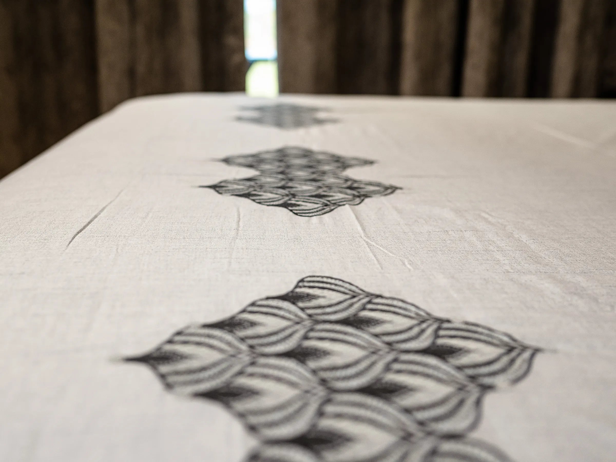 Detailed view of Solace luxury cotton bedsheet featuring centered embroidered motifs, breathable smooth texture, and sophisticated modern elegance