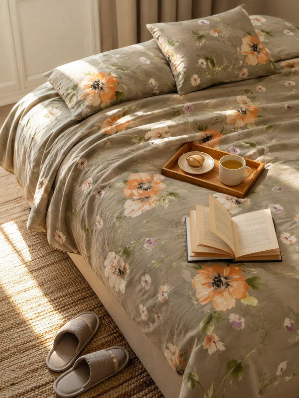 Muse luxury greyish green cotton bedsheet styled on a premium bed with tropical floral print, breakfast tray, and elegant bedroom decor