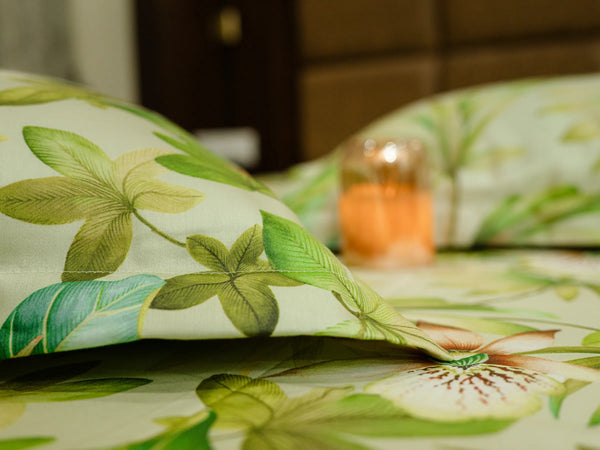 Close-up of luxury jade green 500 thread count organic cotton floral bedsheet with matching pillow covers styled on a super king bed