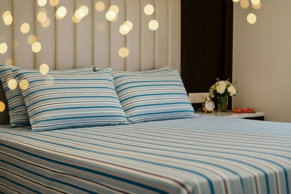 Premium ocean blue organic cotton stripped bedsheet with matching pillow covers on a super king bed featuring blue and purple design 
