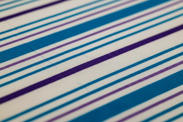Close-up of ocean blue 700 thread count organic cotton bedsheet showcasing elegant blue and purple stripped pattern and soft woven texture