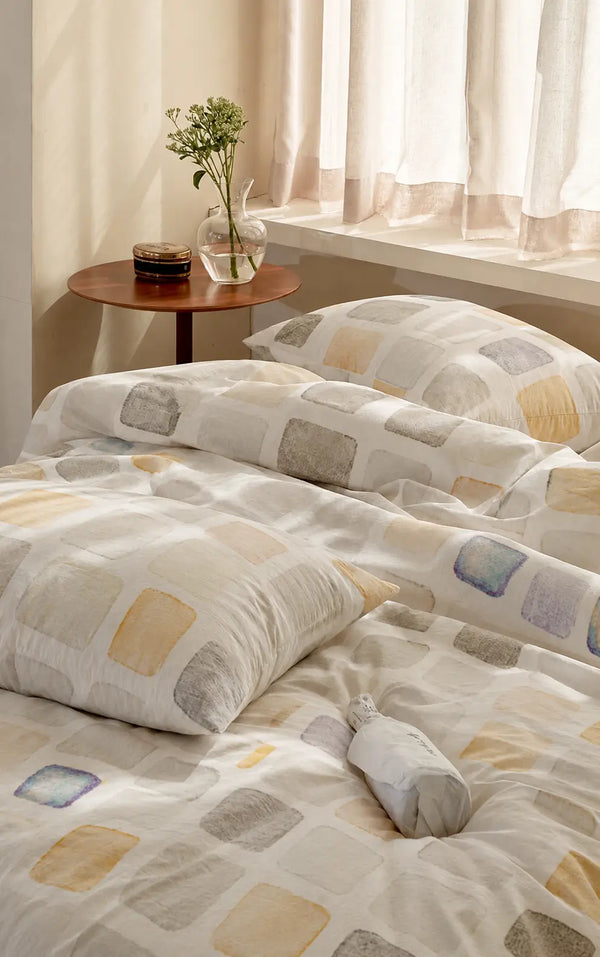 Motif luxury off white cotton bedsheet styled in a modern bedroom featuring a watercolor-inspired geometric design with premium 500 thread count fabric