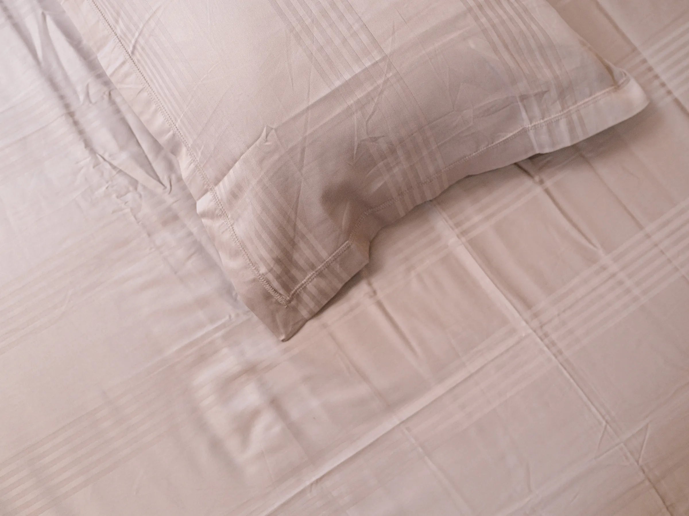 Zenith steel grey flanged pillow cover on matching self-striped bedsheet highlighting refined stitching and soft organic cotton fabric
