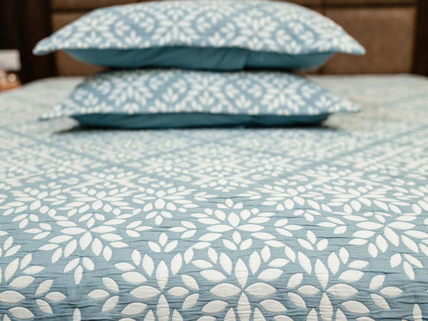 Close up of luxury cotton bedsheet showcasing jacquard design with two pillows kept on the bed 