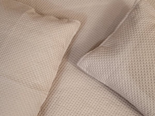 Close up of two pillow corners kept side by side on Chateau beige quilted organic cotton bedsheet with matching pillow cover highlighting elegant stitched texture and 500 thread count fabric