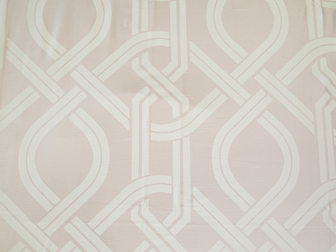 Detailed view of Chaste jacquard bedsheet fabric featuring an interlocking geometric motif in beige for a modern luxury bedroom aesthetic