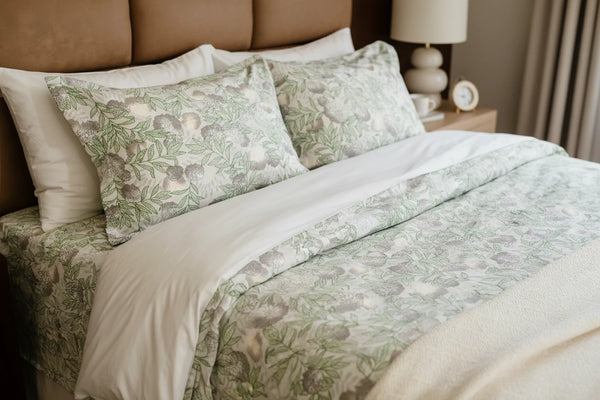Alchemy green and grey floral cotton bedsheet styled on a premium bed with matching pillow covers for a serene lifestyle bedroom look