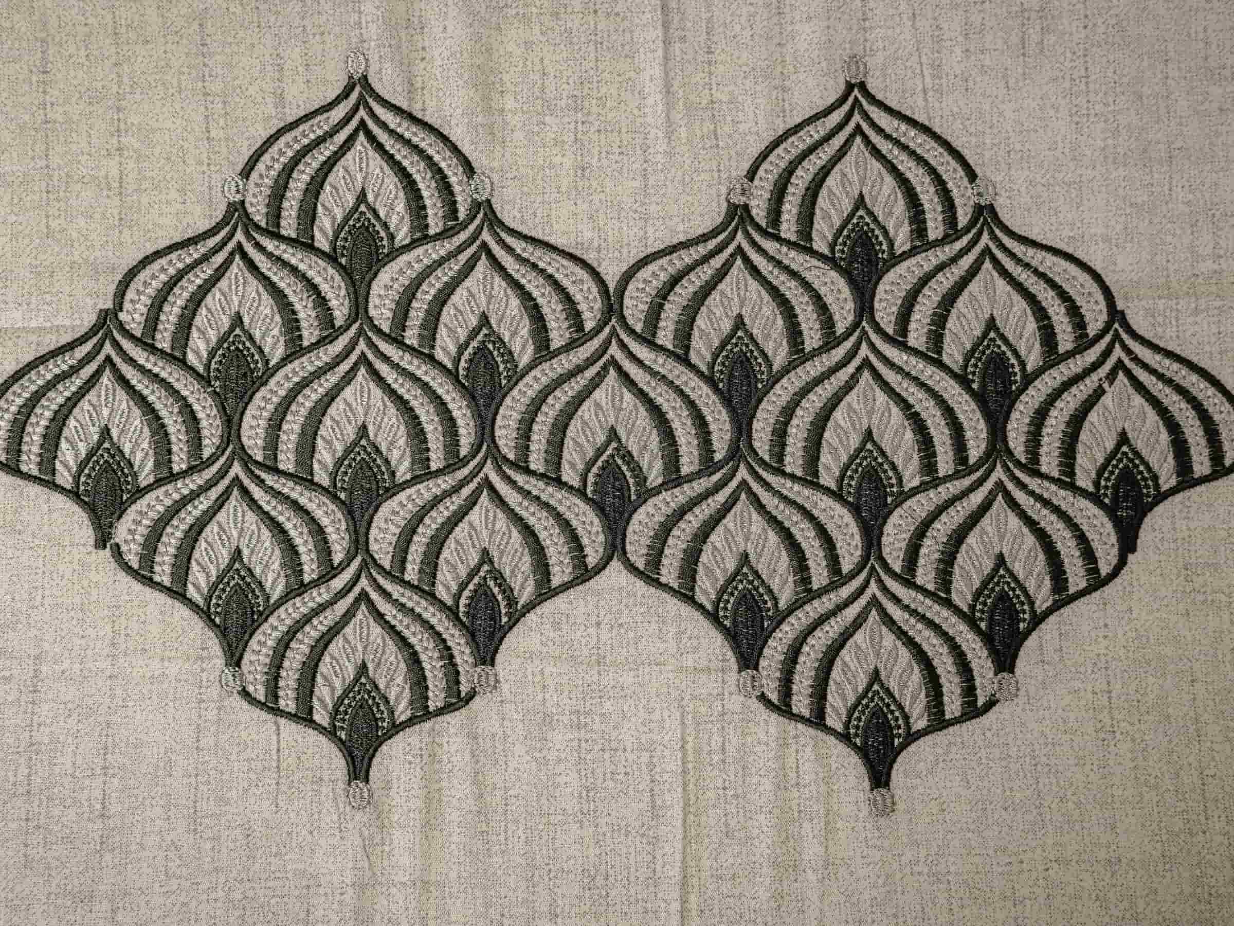 Close-up of Solace luxury bedsheet highlighting intricate self-embroidered geometric motifs on soft greyish blue 500 thread count cotton fabric.