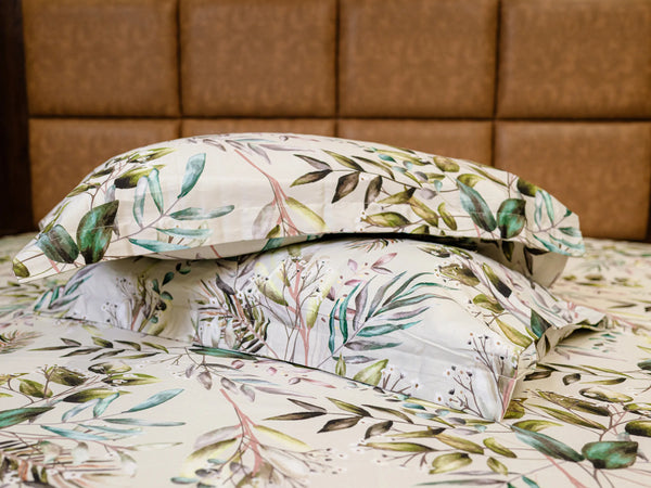 Two pillow covers one over other displaying Cadence luxury cotton bedsheet styled on a modern bed with matching pillow covers and refined tropical floral design