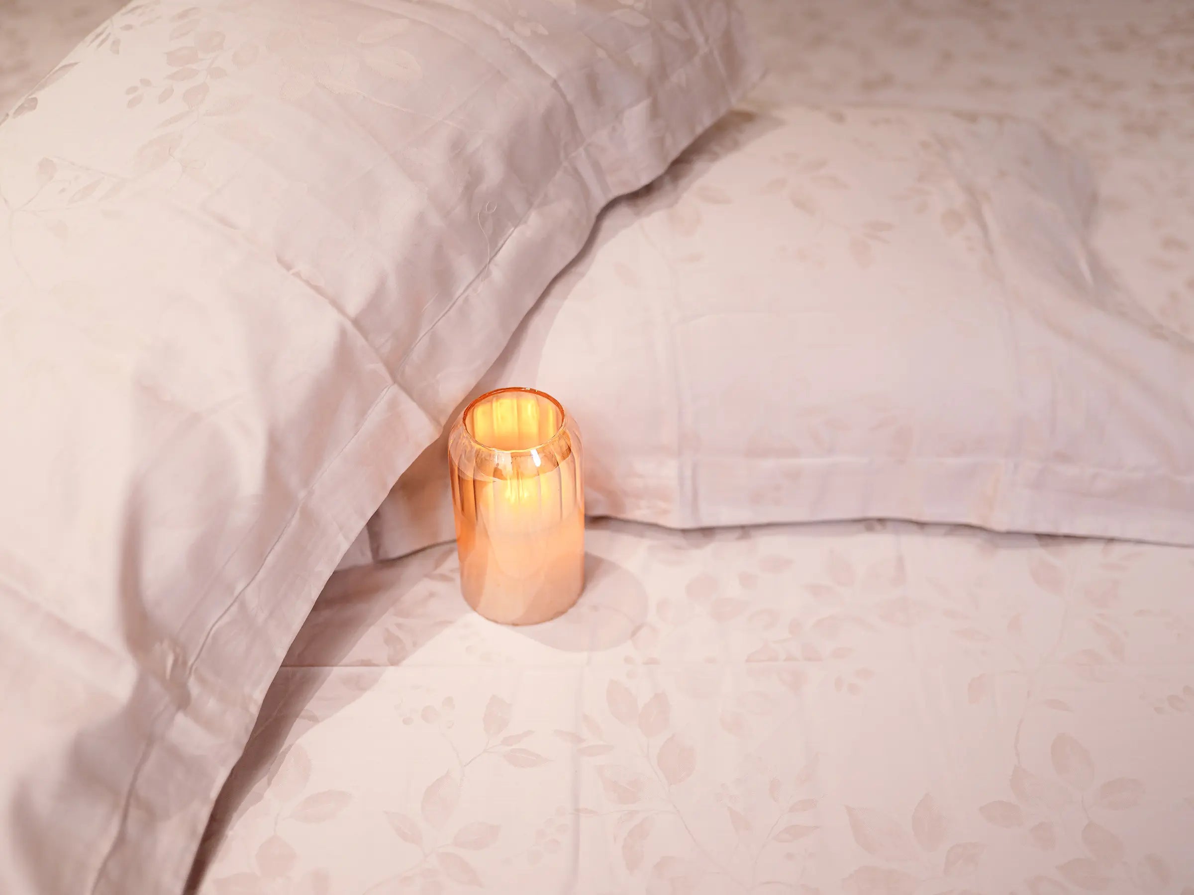 Detailed view of pink champagne jacquard bedsheet highlighting intricate woven pattern and luxurious organic cotton finish