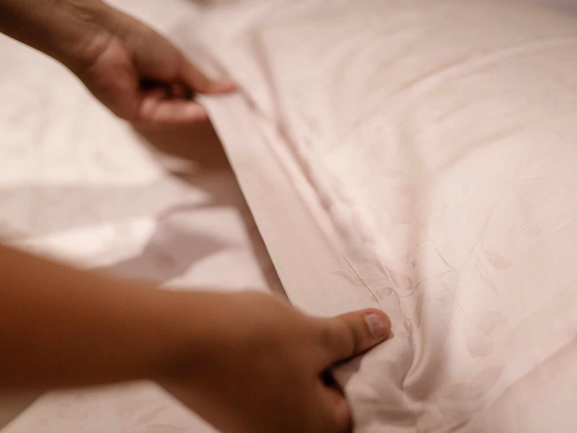 Close_up of soft pink champagne 1000 thread count organic cotton jacquard bedsheet featuring elegant woven texture and silky finish