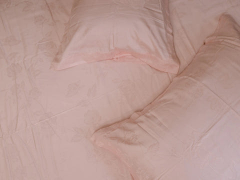 Detailed view of rose gold jacquard bedsheet highlighting elegant woven pattern and luxurious organic cotton finish 