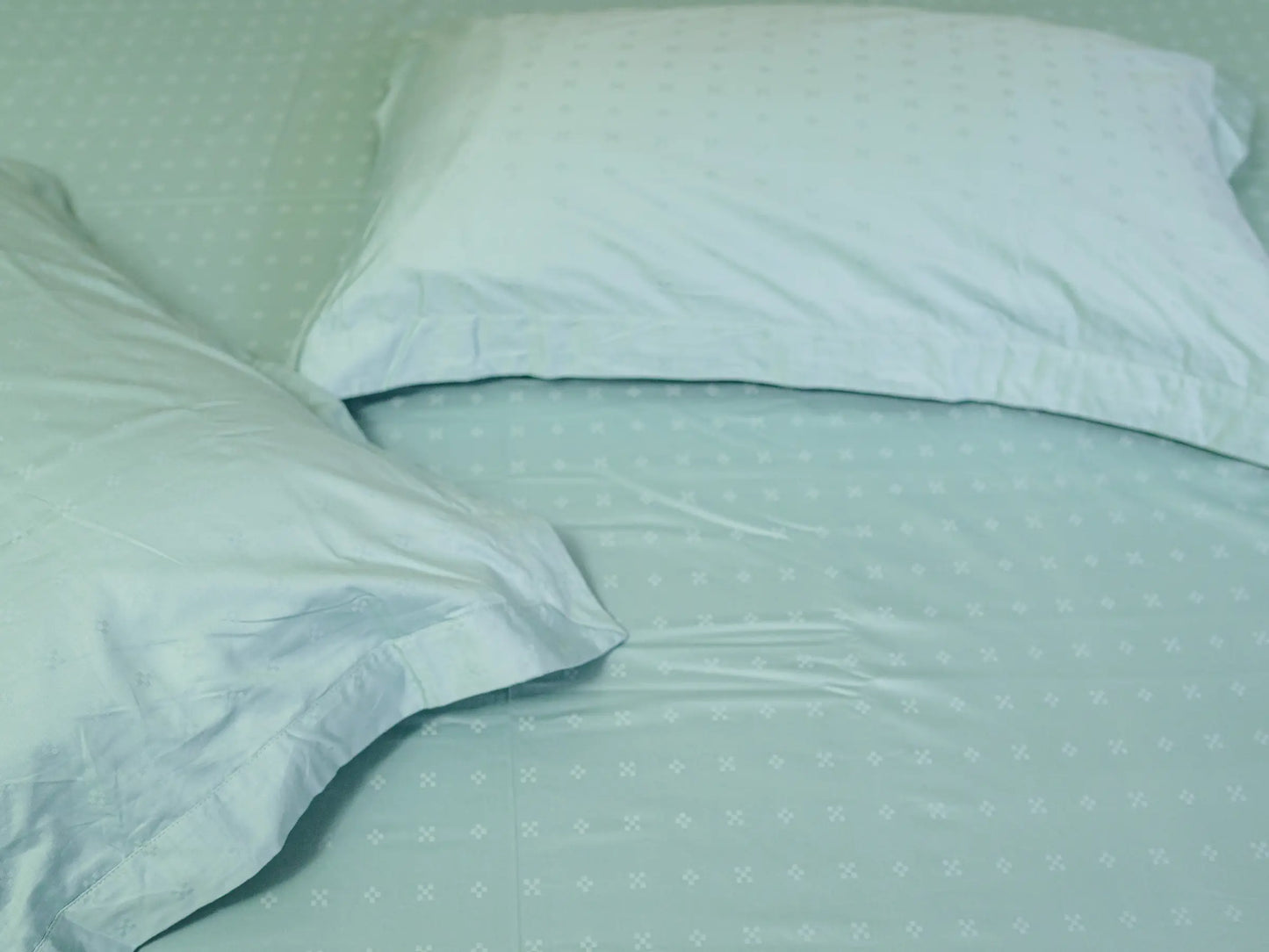 Detailed view of luxury sea green Swiss dot cotton fabric featuring elegant raised dot texture and smooth weave