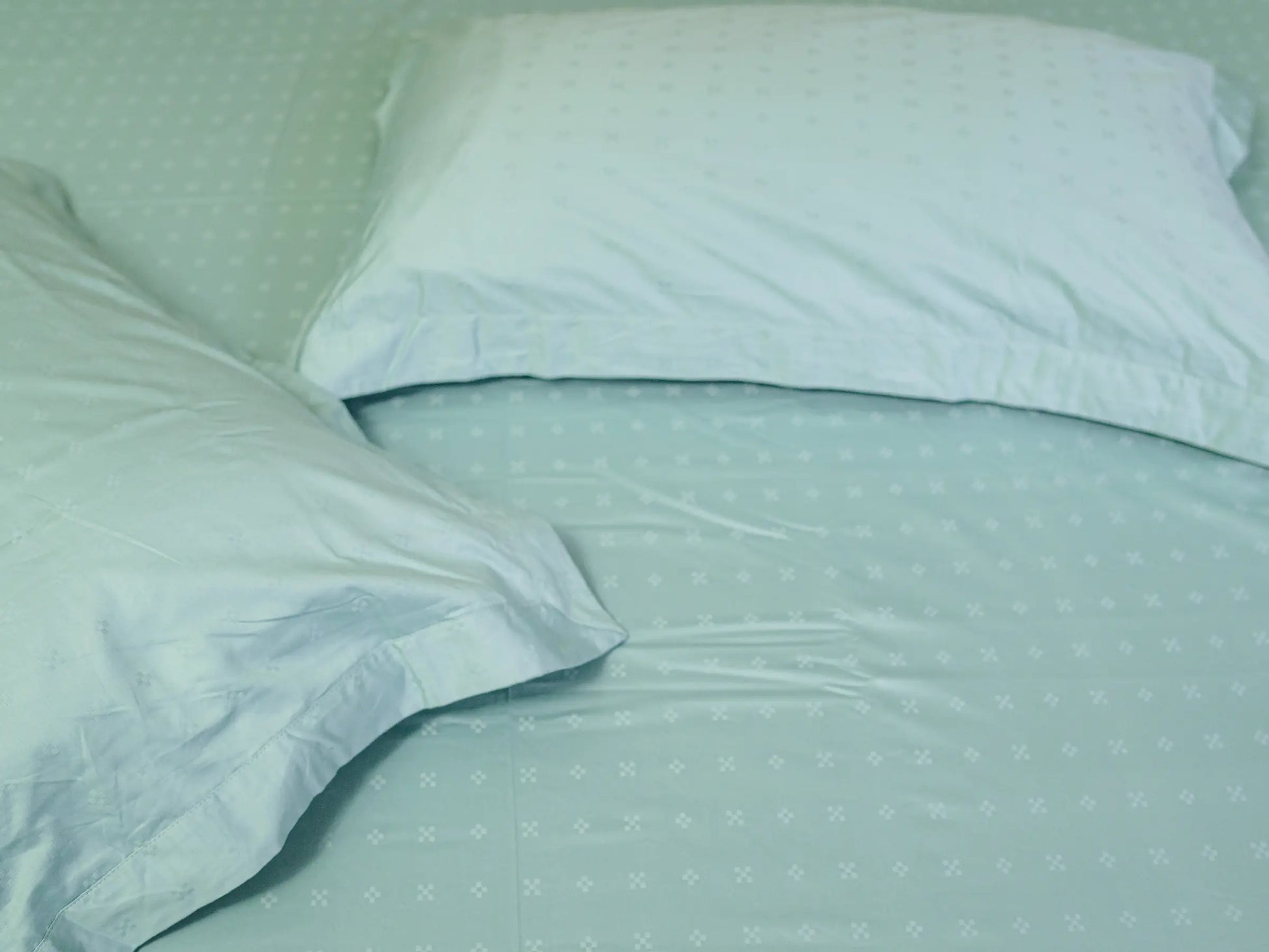 Detailed view of luxury sea green Swiss dot cotton fabric featuring elegant raised dot texture and smooth weave