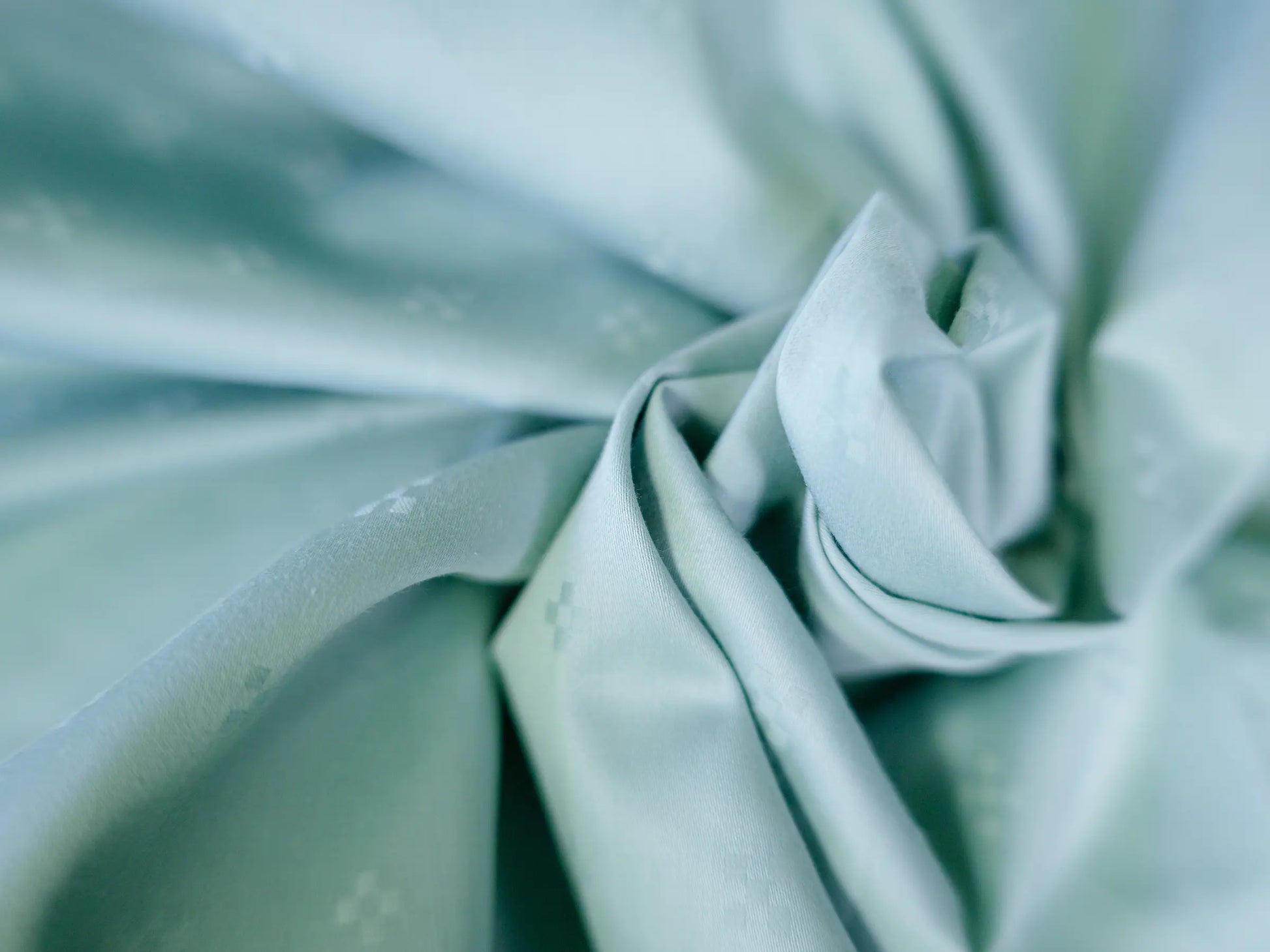 Premium organic cotton Swiss dot bedsheet folded to showcase rich texture, superior softness and luxury craftsmanship