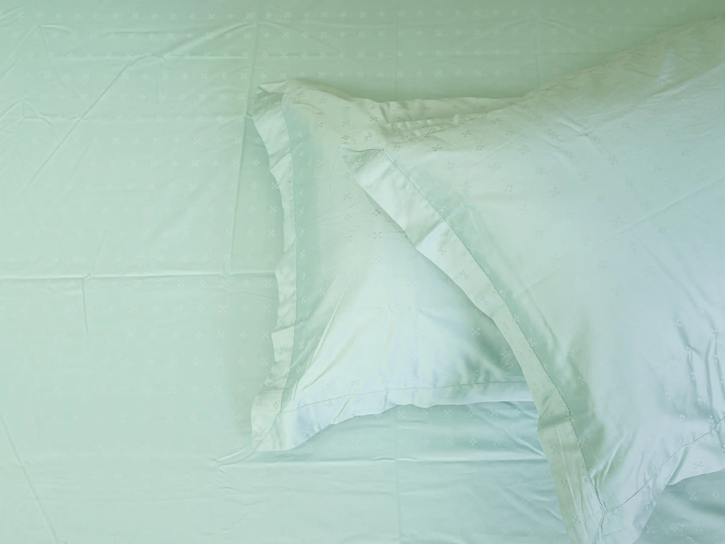 Macro shot of premium 500 thread count sea green cotton bedsheet revealing breathable , Buttery-soft Swiss dot texture