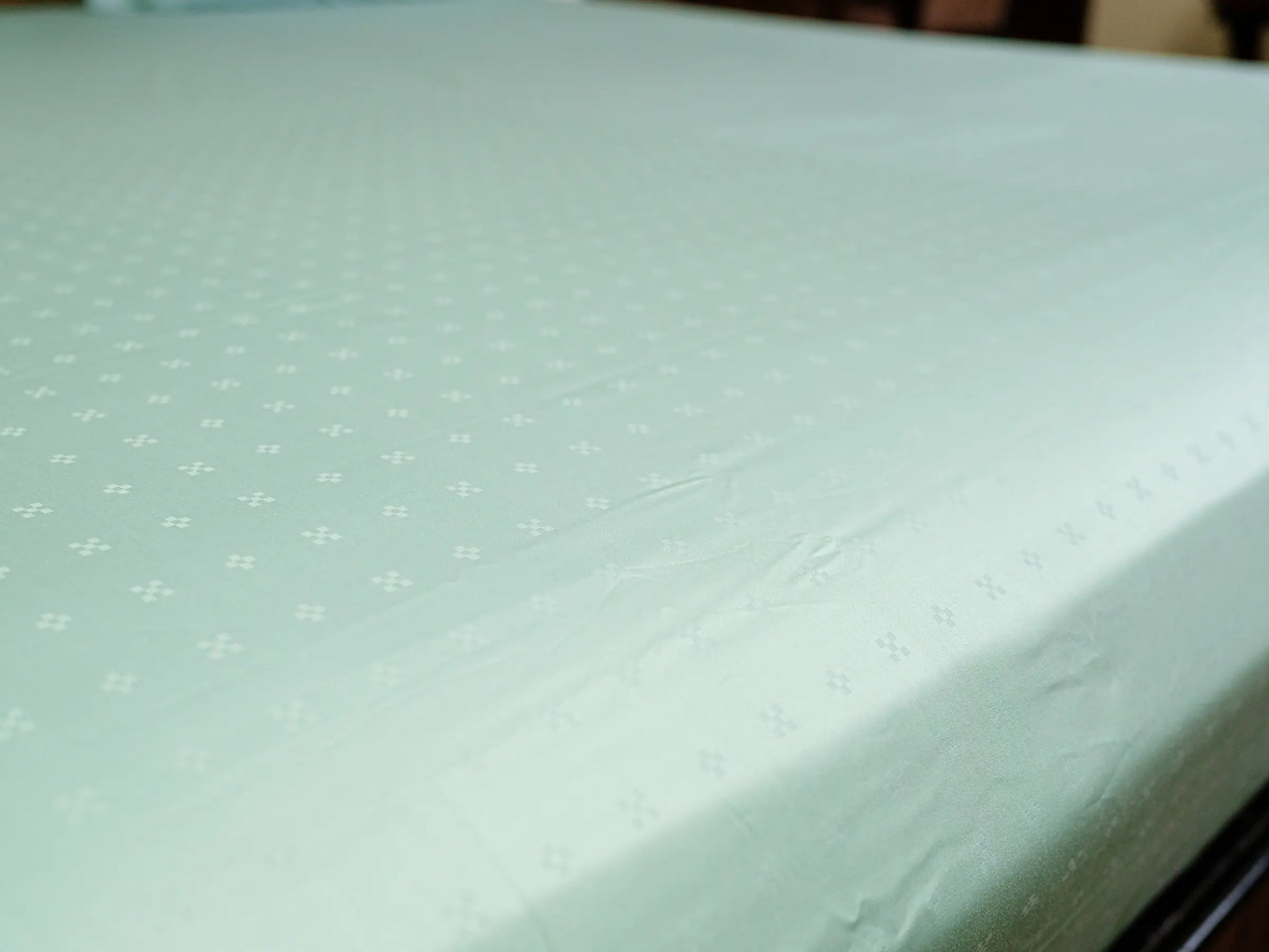 Luxury sea green cotton bedsheet with graceful drape and wrinkle-resistant finish for an elegant bedroom aesthetic