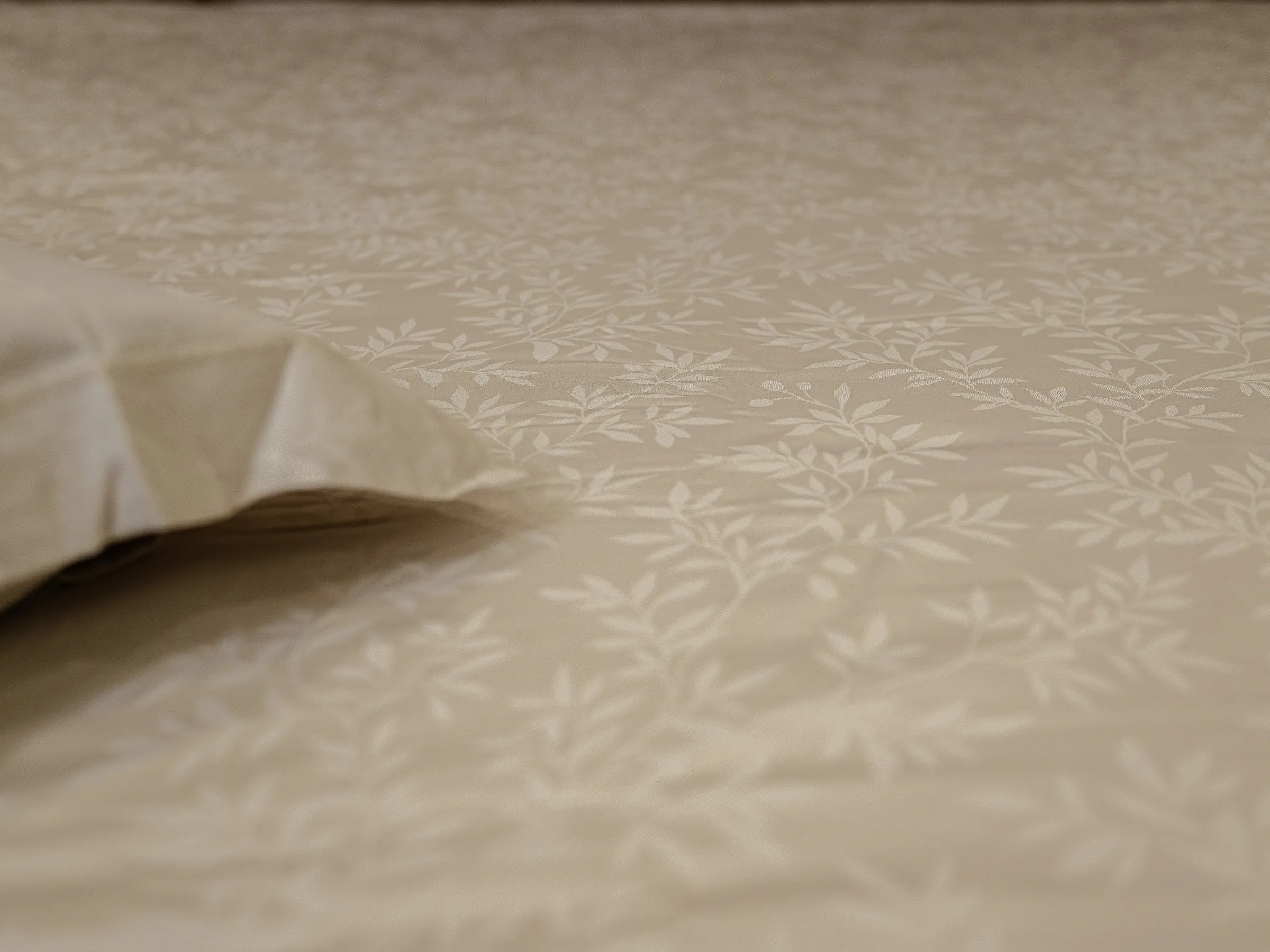 Close-up of Svelte luxury linen bedsheet highlighting subtle botanical vine self-jacquard pattern and soft hypoallergenic fabric