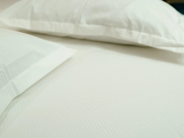 Close-up of Apex snow white luxury bedsheet with matching pillow cover showcasing smooth 500 thread count cotton texture